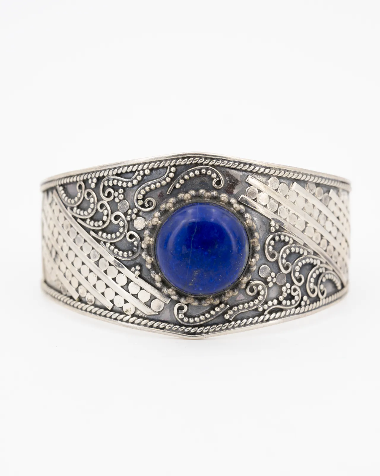 Un bracelet en argent fait main avec des motifs élégants et serti d'un lapis lazuli rond