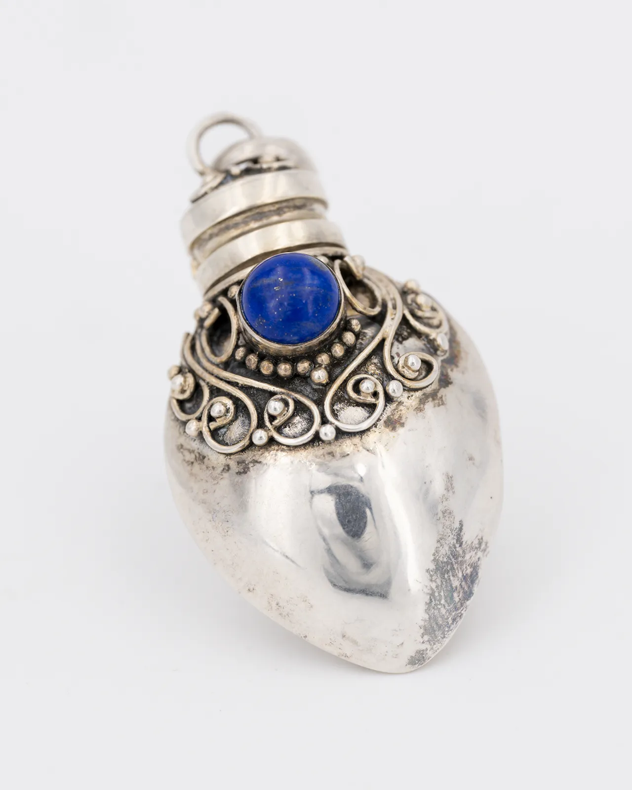 Un pendentif en argent en forme de fiole serti d'un lapis lazuli - artisanat balinais